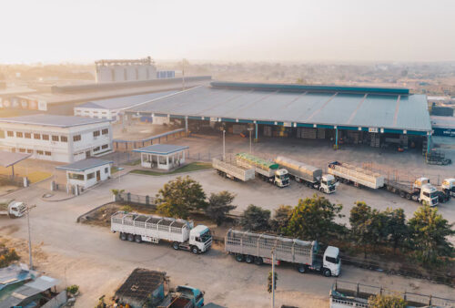 aerial-view-factory-trucks-parked-near-warehouse-daytime_181624-4593