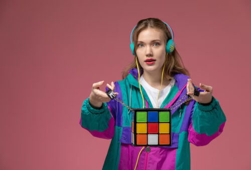 front-view-young-attractive-female-colored-coat-listening-music-holding-funny-bag-dark-pink-wall-model-color-female-young-girl_140725-37730